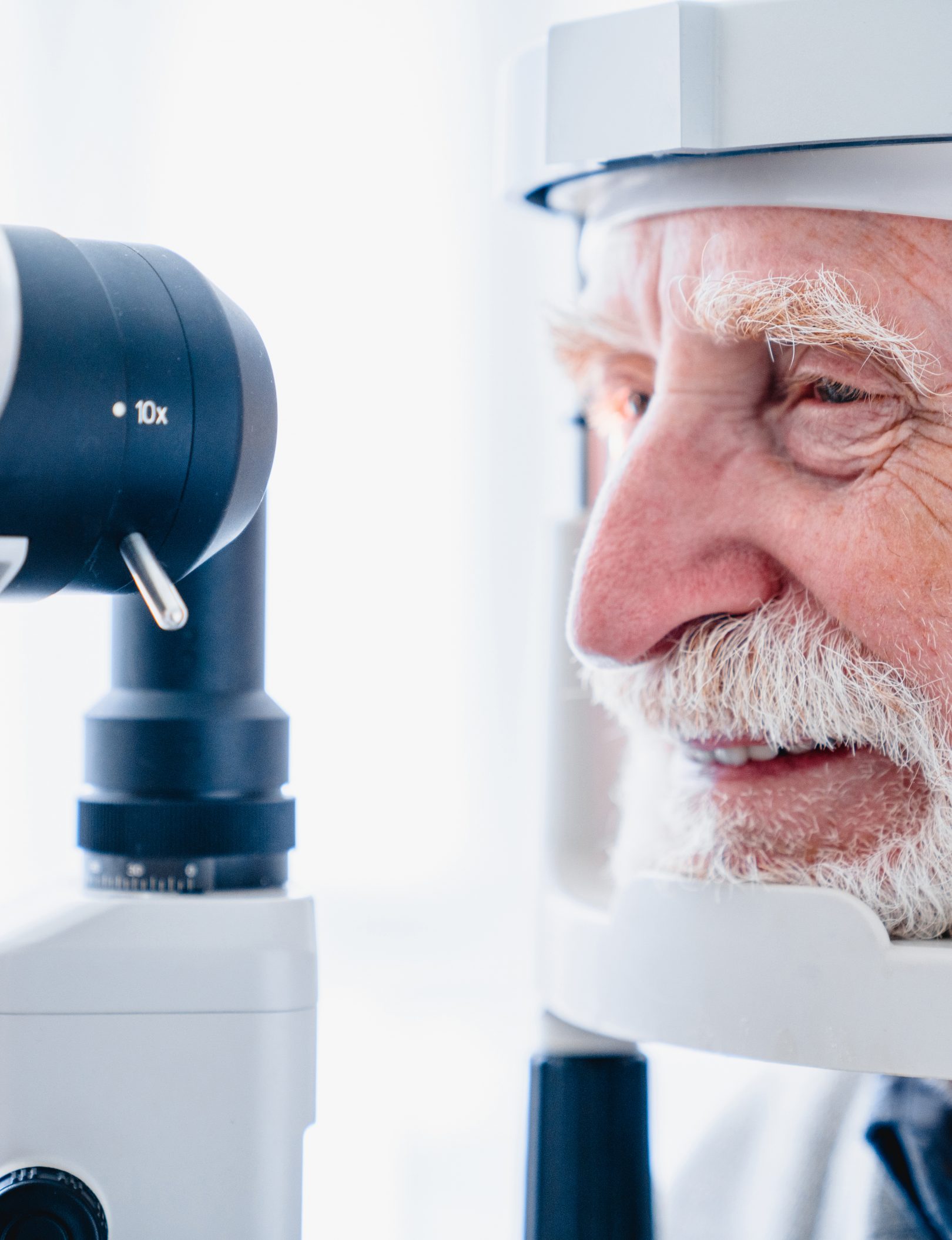 Cropped photo of happy senior patient being diagnosed with ophthalmic equipment