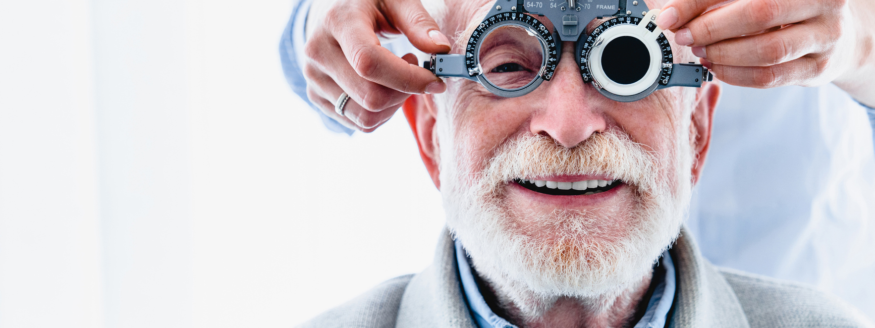 Portrait of a happy mature male patient undergoing vision check with special ophthalmic glasses